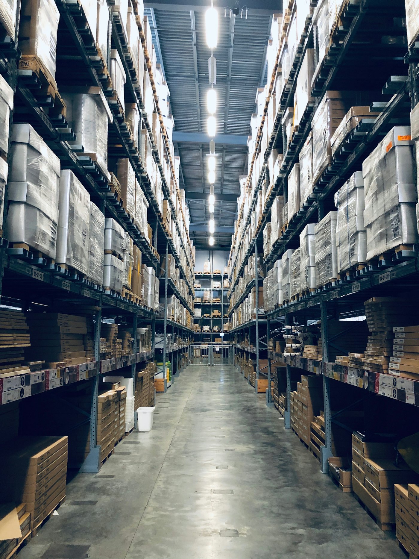 A fulfillment warehouse aisle lined with shelves of packages